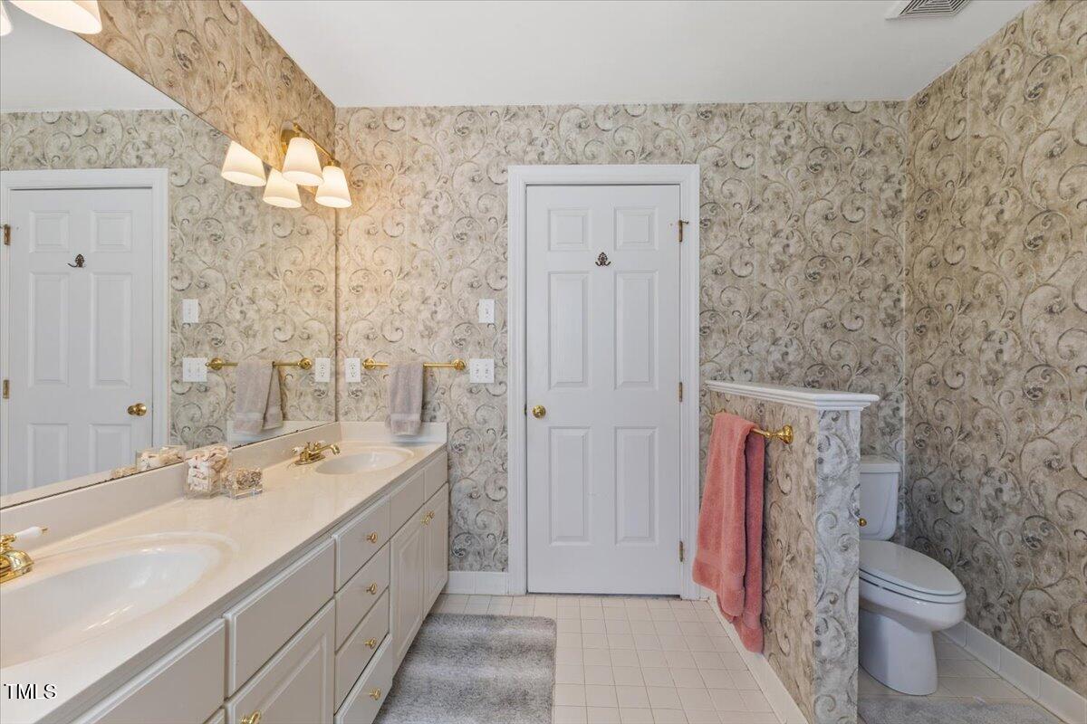 4617 Wee Burn Trail Raleigh, NC 27612 - Photo 42 of 70 a spacious bathroom with a granite countertop sink a toilet and a shower
