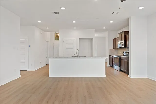 a view of kitchen with stainless steel appliances refrigerator sink and cabinets