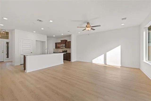 a view of an empty room with a kitchen
