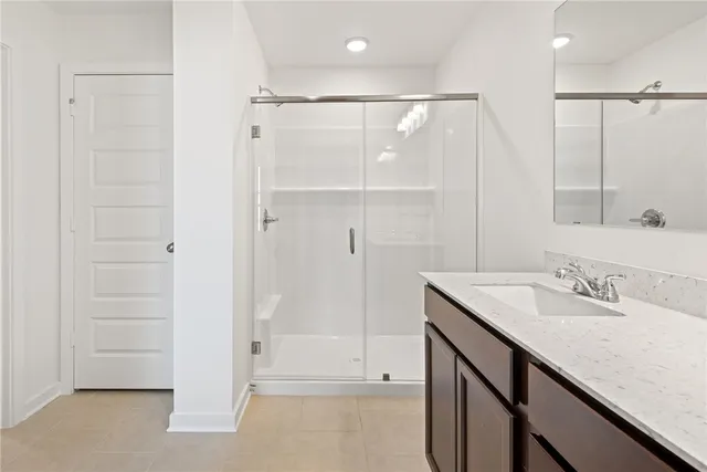 a bathroom with a shower sink and mirror