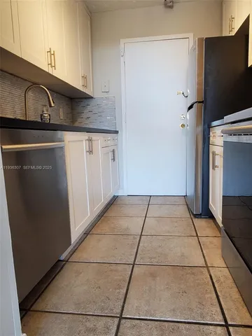a kitchen with a sink a refrigerator and cabinets