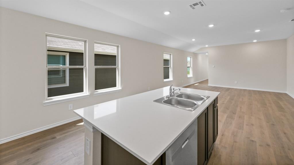 657 Glee Stem Road Lavon, TX 75166 - Photo 7 of 26 a kitchen with kitchen island a sink table and chairs