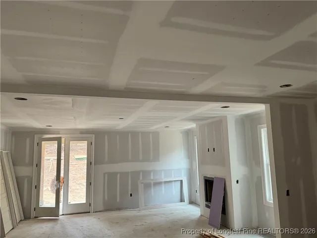 a view of an empty room with window and fireplace