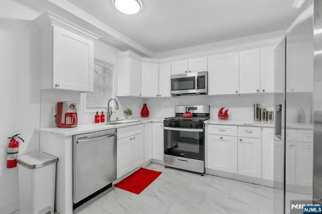 a kitchen with cabinets appliances and a window