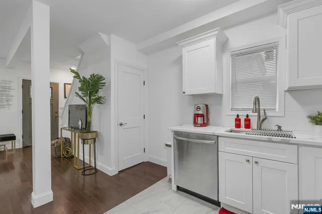 a kitchen with kitchen island a sink cabinets and wooden floor