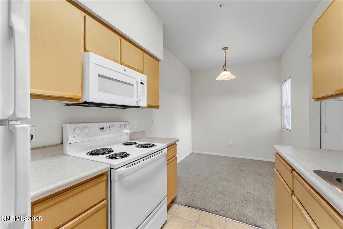 6850 Sharlands Avenue Reno, NV 89523 - Photo 13 of 25 a kitchen with granite countertop a stove a sink and a microwave
