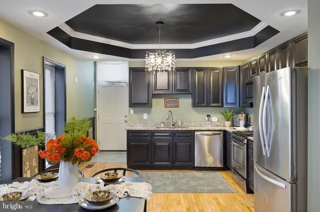 a kitchen with kitchen island granite countertop stainless steel appliances cabinets a sink and a counter top space