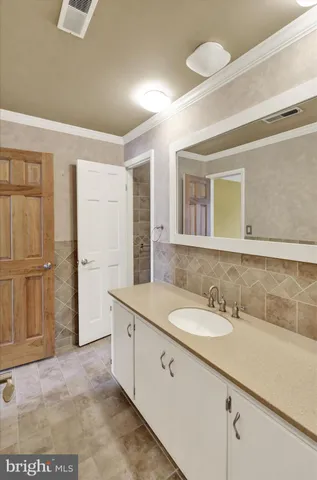 a bathroom with a granite countertop sink and a mirror