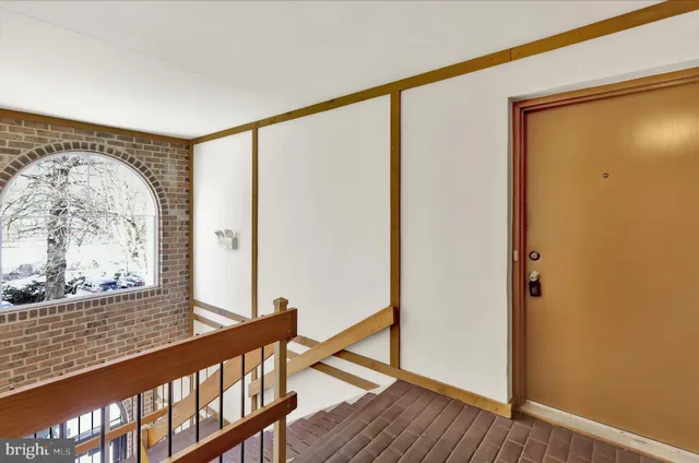 a view of a big room with wooden floor and windows