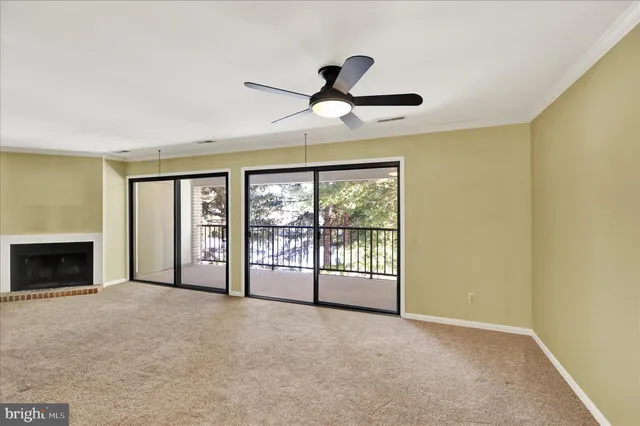 a view of an empty room with a fireplace and a window