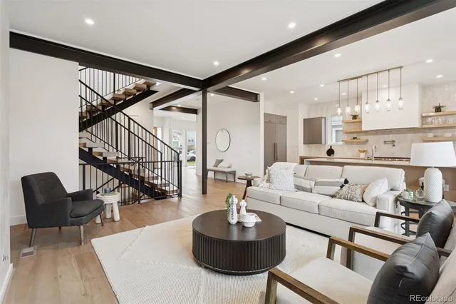 a living room with furniture kitchen view and a chandelier