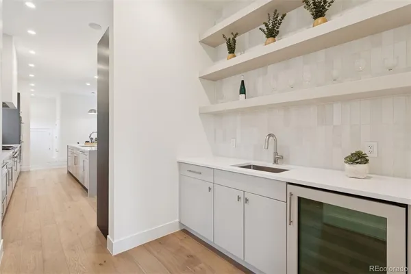 a kitchen with a sink dishwasher and cabinets with wooden floor