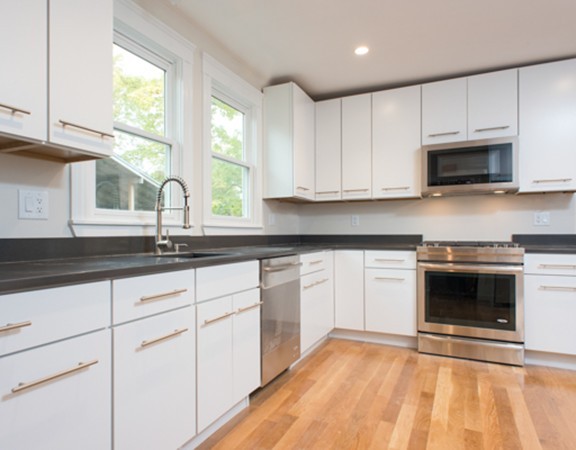 3 Wilson Avenue, Unit 2 Cambridge, MA 02140 - Photo 6 of 17 a kitchen with granite countertop white cabinets stainless steel appliances a sink and a window