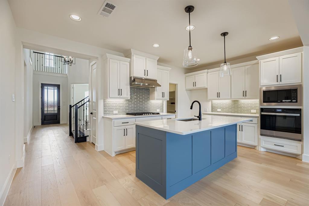 2204 Berman Street Celina, TX 75009 - Photo 8 of 28 a kitchen with stainless steel appliances granite countertop a sink refrigerator and cabinets