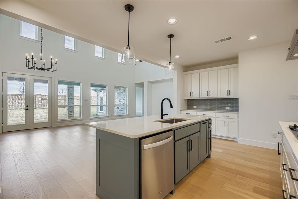 2204 Berman Street Celina, TX 75009 - Photo 9 of 28 a kitchen with a sink a center island a stove and a window