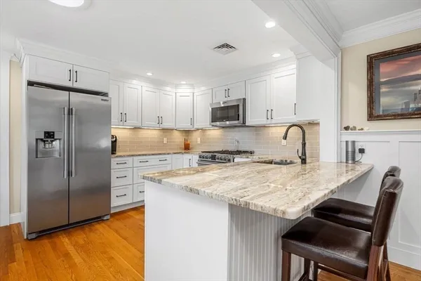 a kitchen with kitchen island a refrigerator stove microwave and cabinets