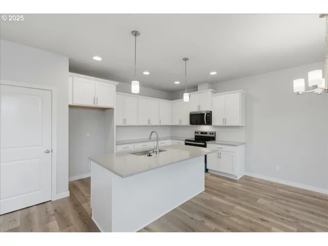 a kitchen with kitchen island a sink stainless steel appliances and cabinets