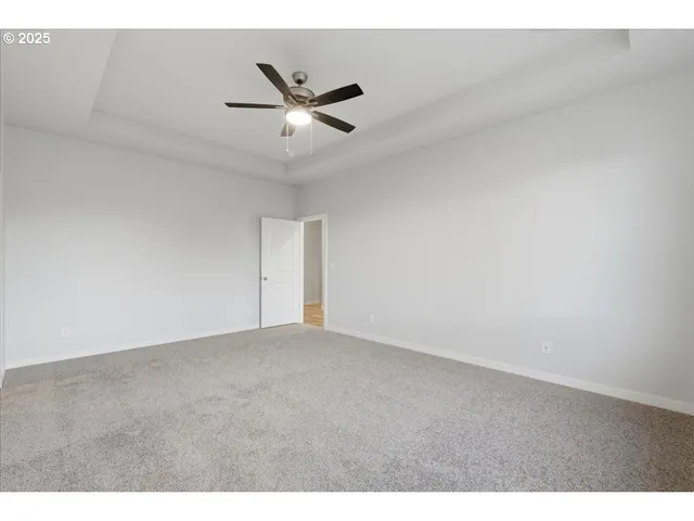a view of an empty room with wooden floor and a fireplace