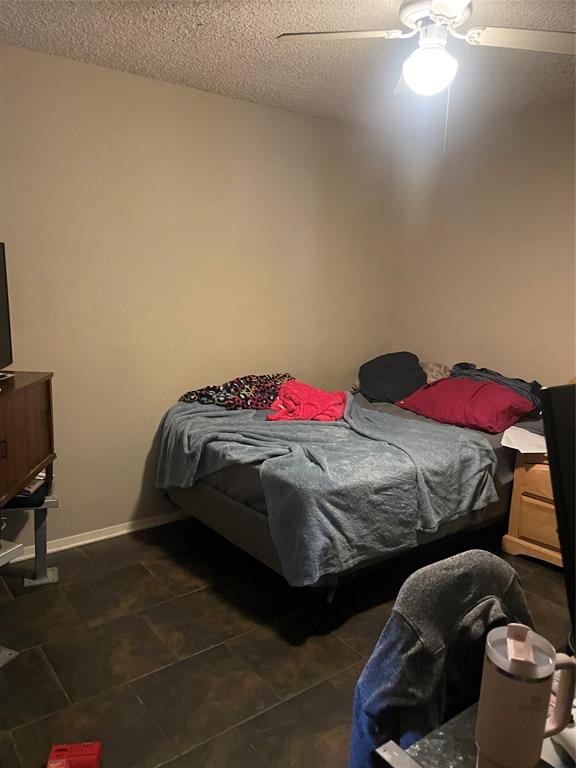 814 Plum Street Graham, TX 76450 - Photo 11 of 25 a bedroom with a bed and a chair