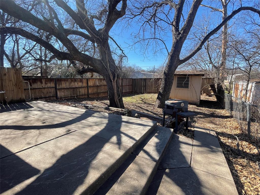 814 Plum Street Graham, TX 76450 - Photo 18 of 25 a view of a backyard with table and chairs under a large tree