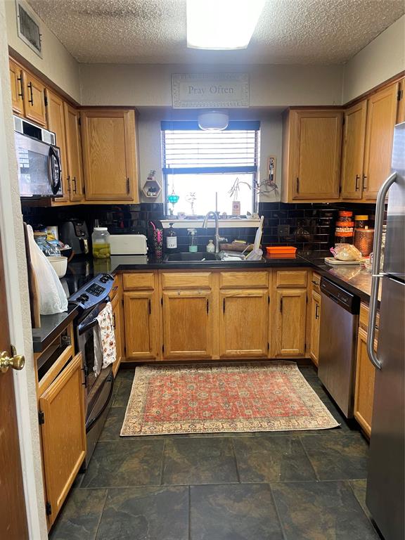 814 Plum Street Graham, TX 76450 - Photo 20 of 25 a kitchen with a sink window and cabinets