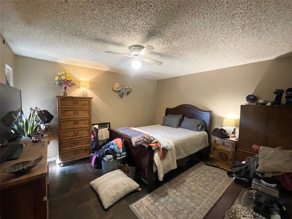 814 Plum Street Graham, TX 76450 - Photo 21 of 25 a bedroom with bed and a dresser
