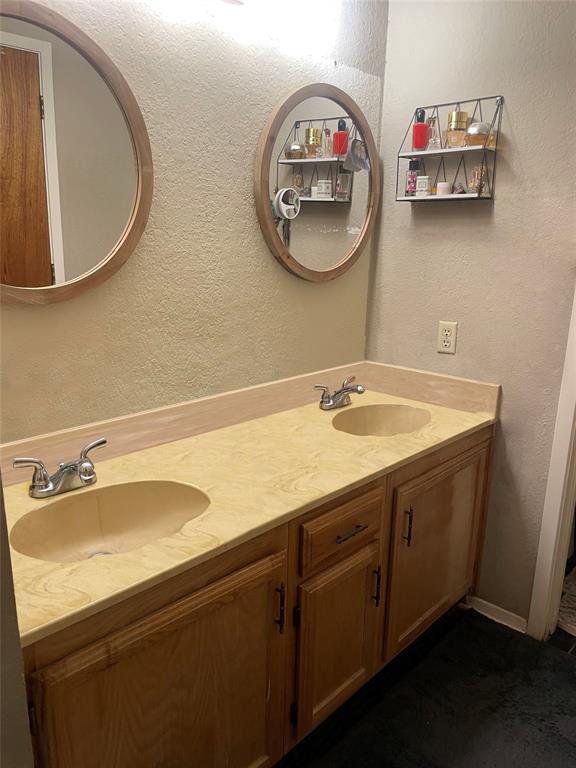 814 Plum Street Graham, TX 76450 - Photo 22 of 25 a bathroom with a sink and a mirror