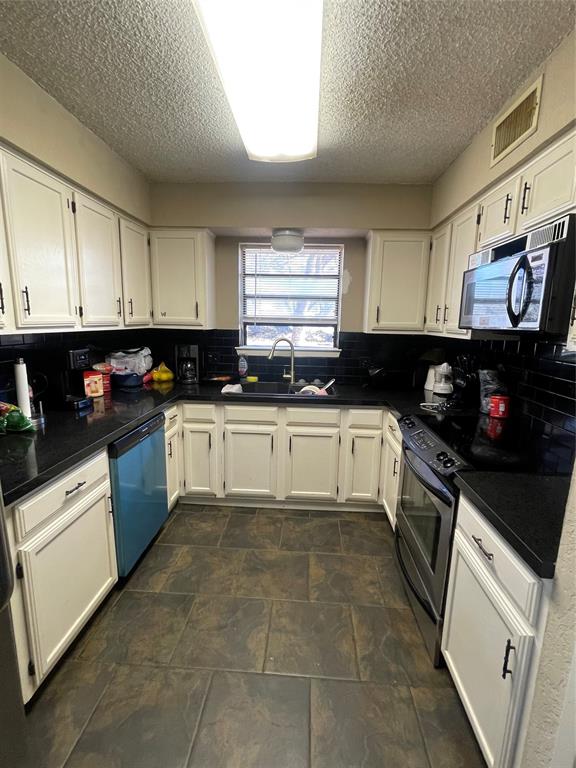 814 Plum Street Graham, TX 76450 - Photo 8 of 25 a kitchen with granite countertop a sink a window and cabinets