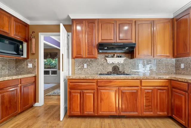 a kitchen with granite countertop wooden cabinets and stainless steel appliances