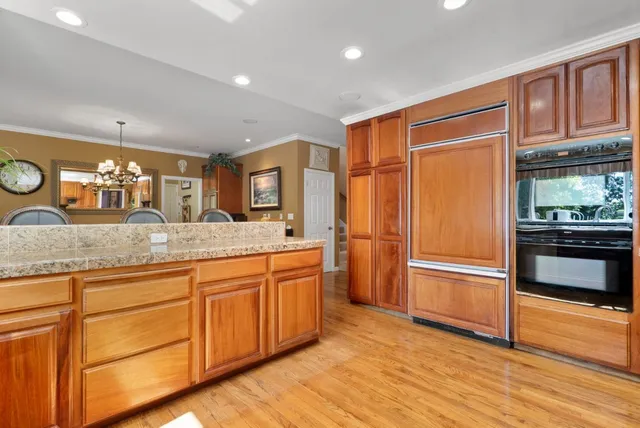 a large kitchen with stainless steel appliances granite countertop a stove a sink and a microwave