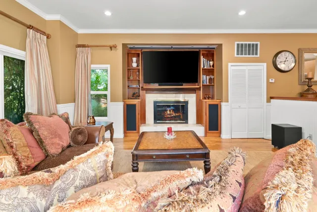 a living room with furniture a large window and a chandelier