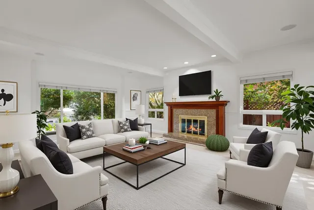 an empty room with windows and fireplace