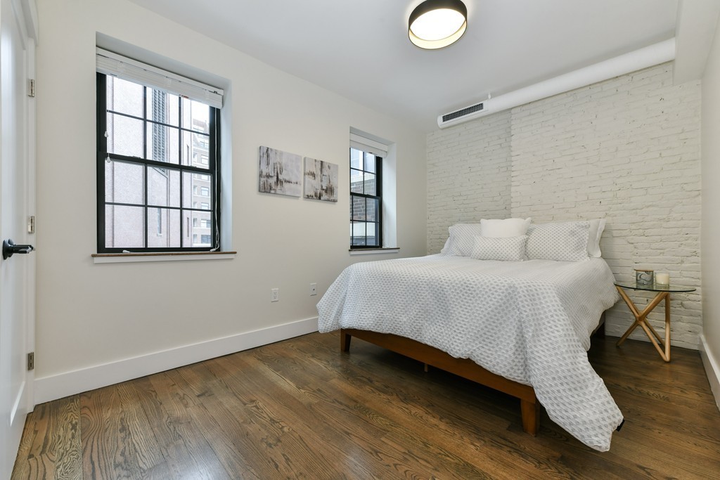 40 Fleet Street, Unit 5 Boston, MA 02113 - Photo 5 of 8 a bedroom with a bed and wooden floor
