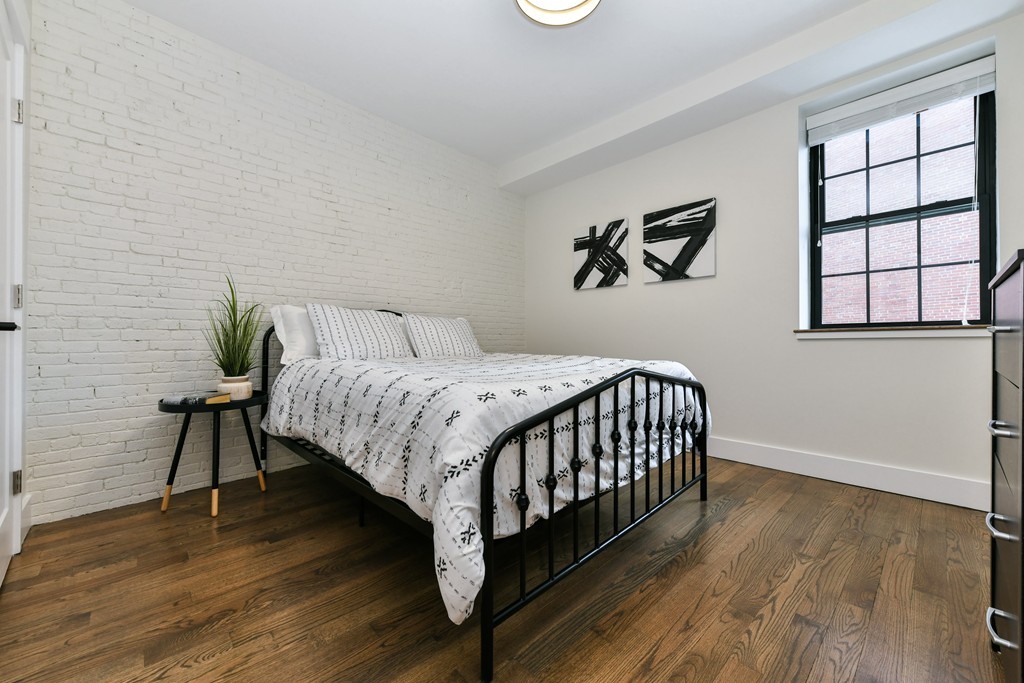 40 Fleet Street, Unit 5 Boston, MA 02113 - Photo 6 of 8 a bedroom with a bed and wooden floor