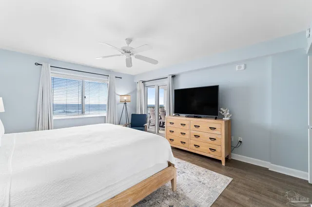 a bedroom with a bed a flat screen tv and dresser