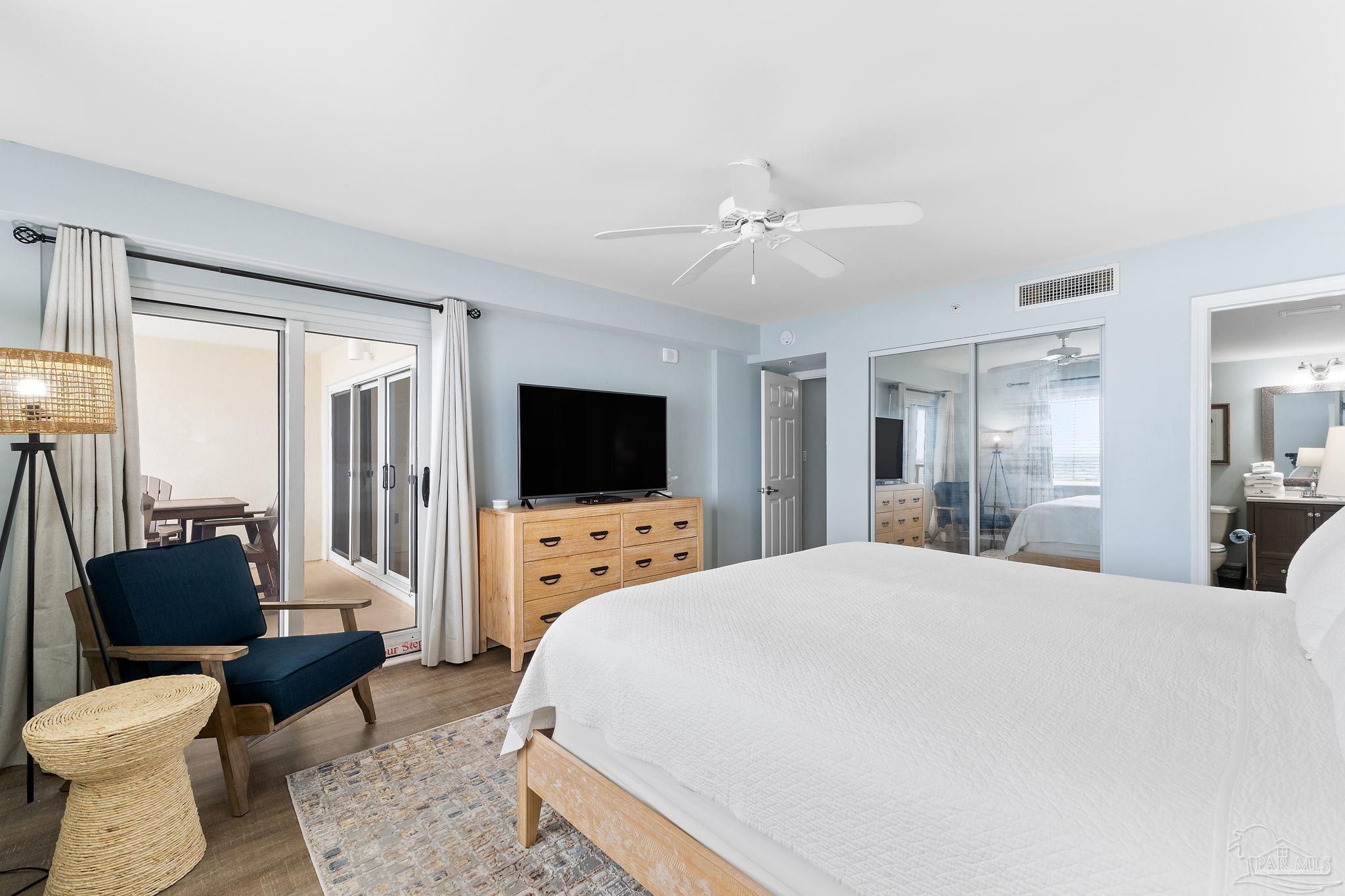 13575 Sandy Key Drive, Unit 335 Pensacola, FL 32507 - Photo 17 of 25 a large bedroom with a bed and a flat screen tv