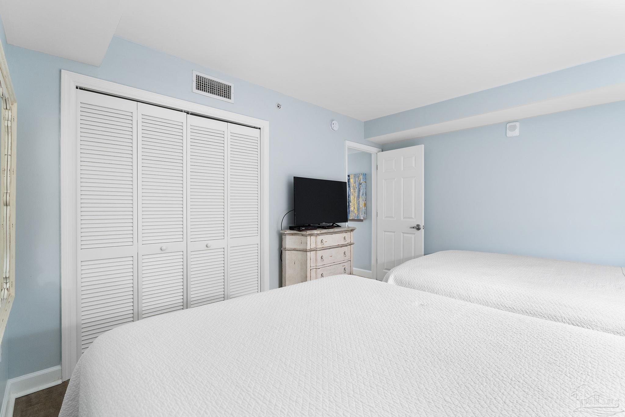 13575 Sandy Key Drive, Unit 335 Pensacola, FL 32507 - Photo 18 of 25 a bedroom with a bed and a flat screen tv