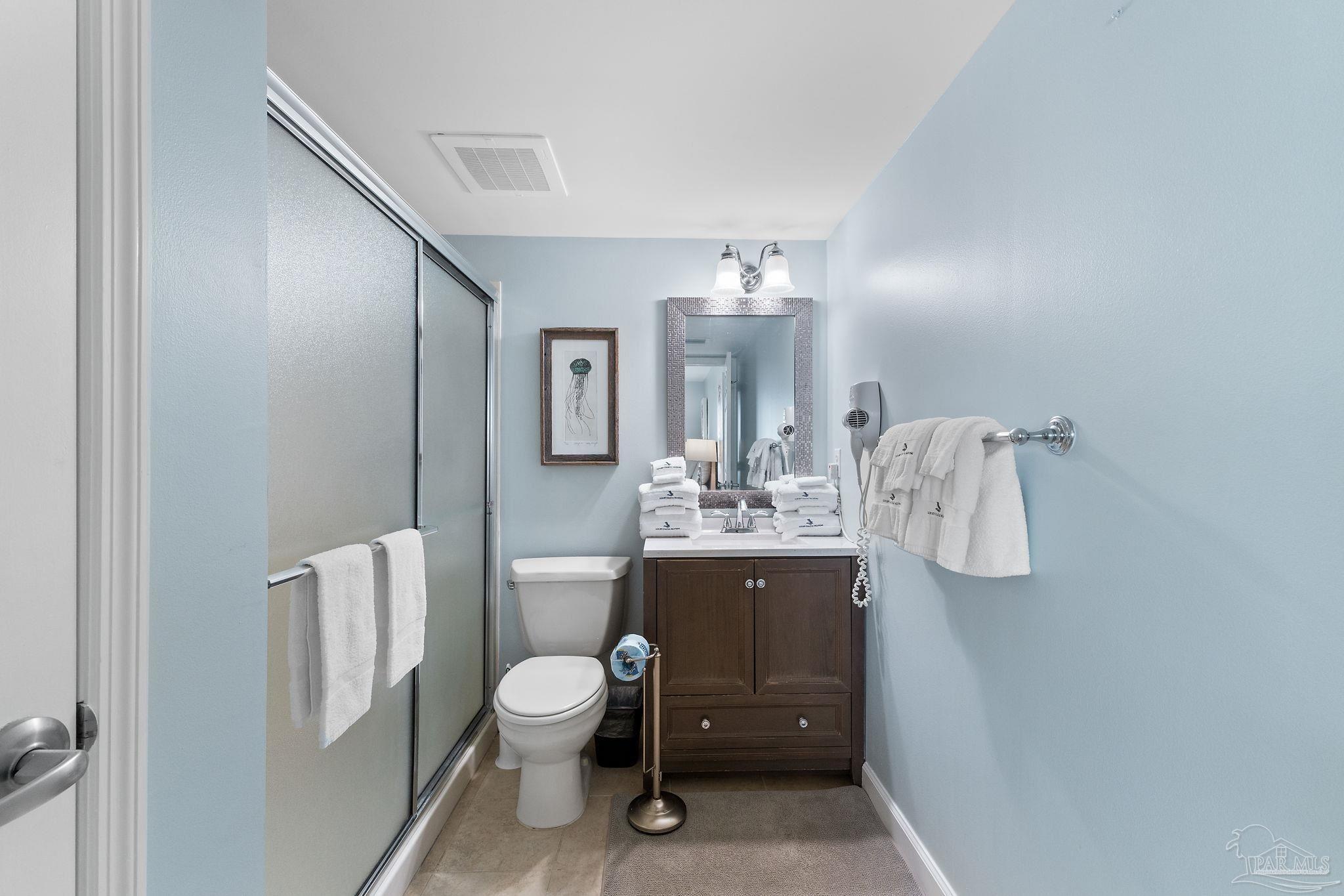13575 Sandy Key Drive, Unit 335 Pensacola, FL 32507 - Photo 19 of 25 a bathroom with a toilet a sink and mirror