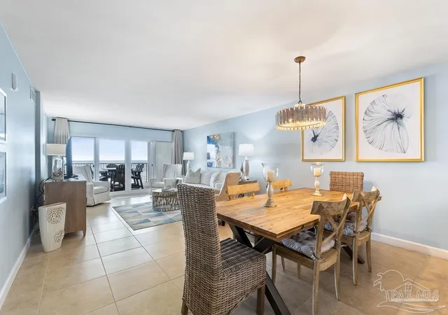 a view of a dining room and livingroom with furniture wooden floor a chandelier
