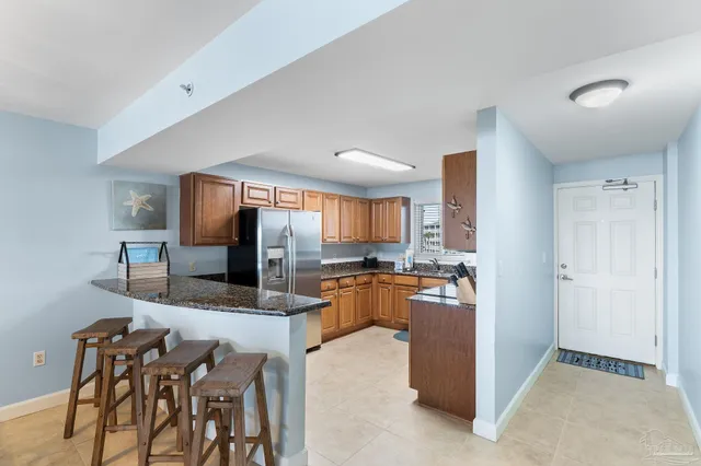 a kitchen with refrigerator and chairs