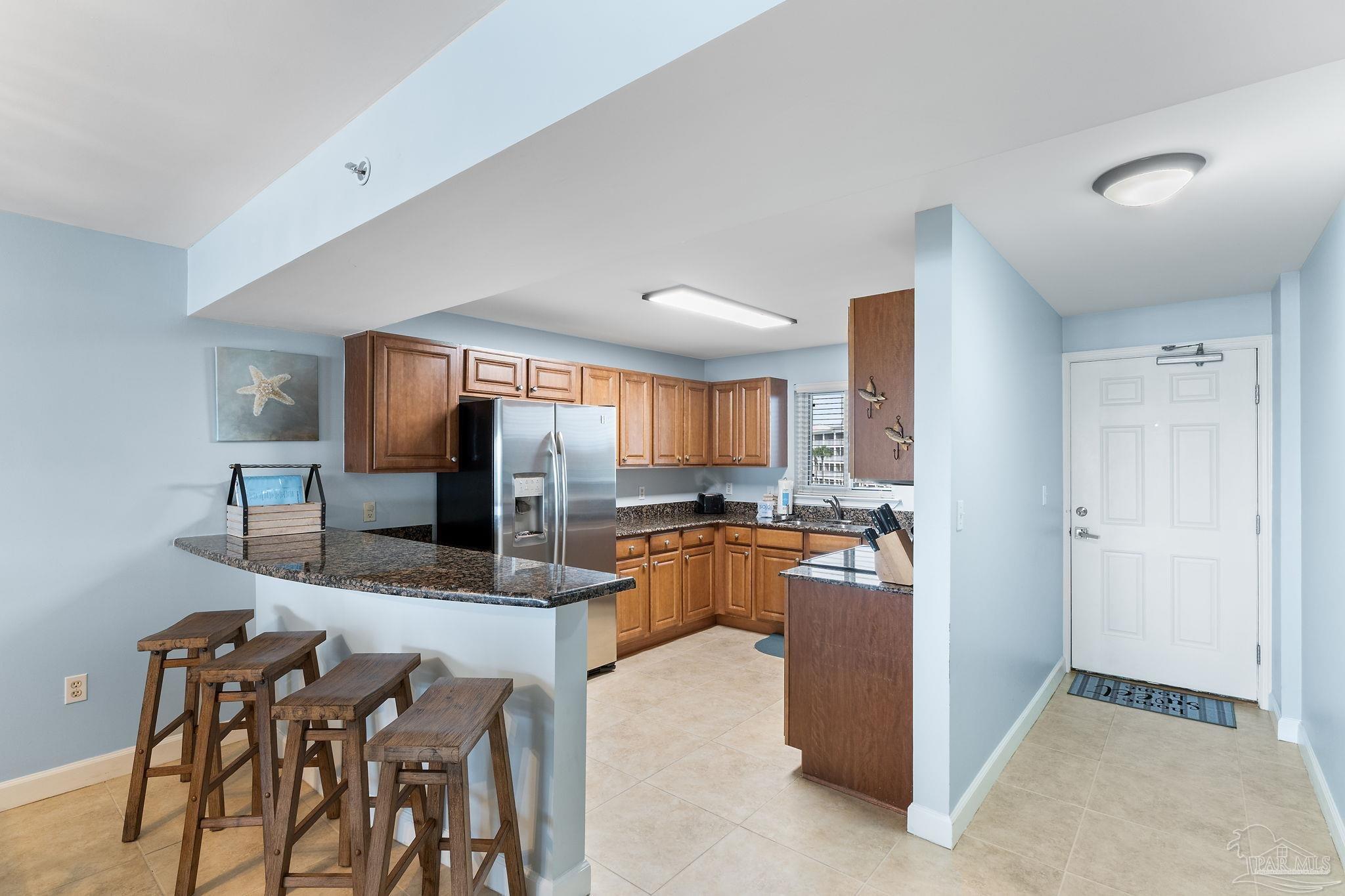 13575 Sandy Key Drive, Unit 335 Pensacola, FL 32507 - Photo 8 of 25 a kitchen with refrigerator and chairs