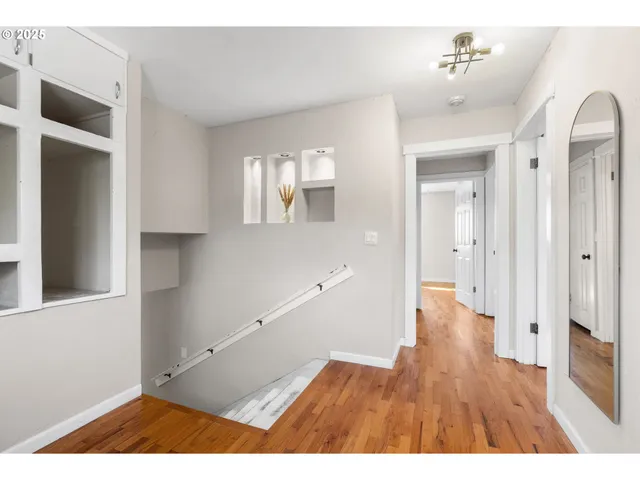 an empty room with wooden floor and window