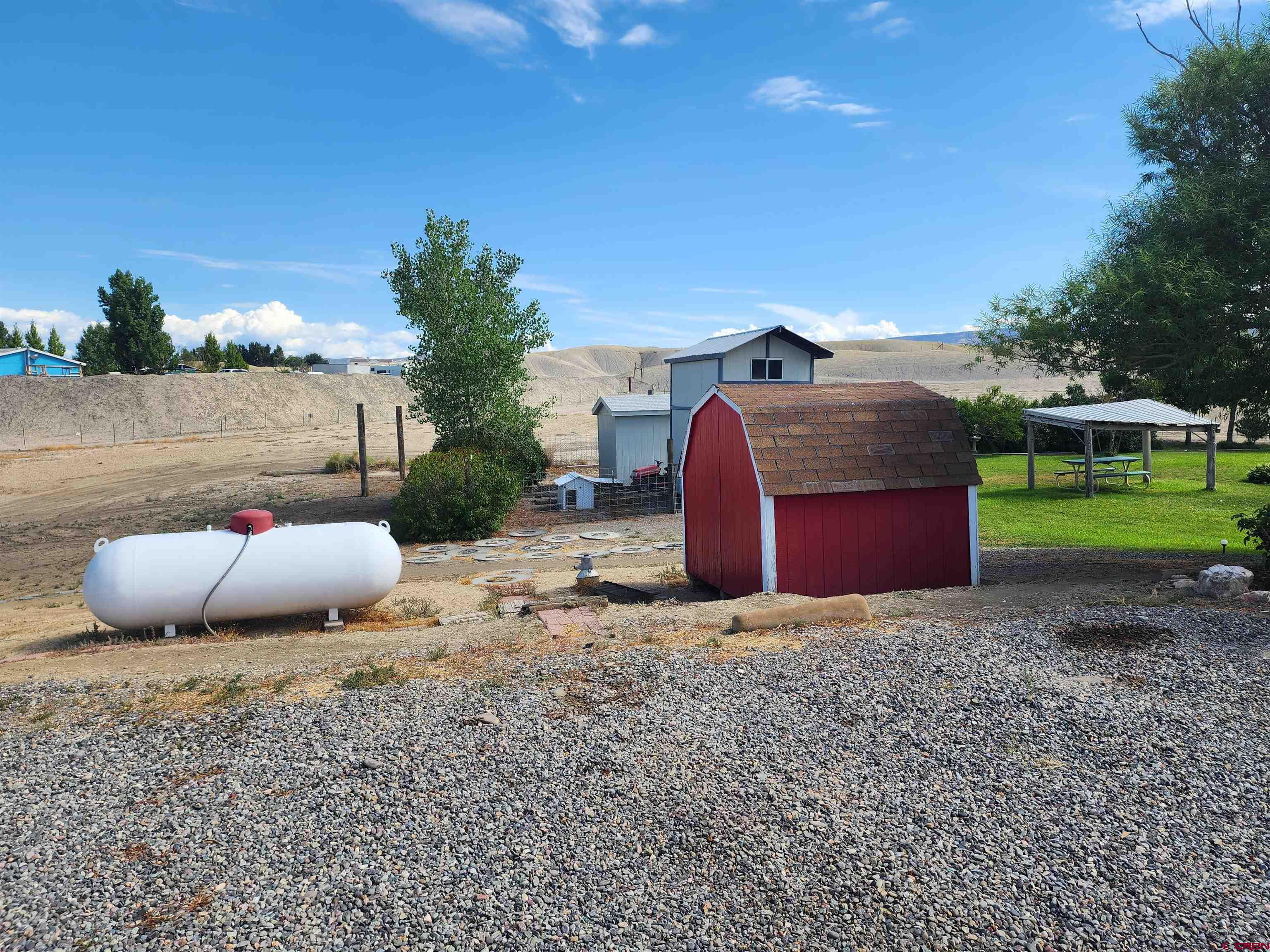 5280 6200th Road Olathe, CO 81425 - Photo 8 of 22 a view of a yard with an outdoor seating and a garage