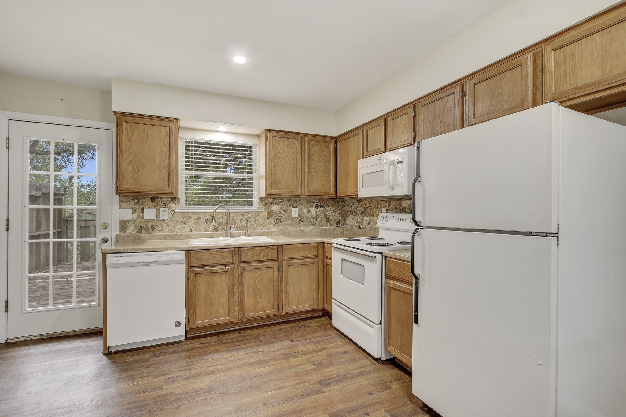 6902 Rifle Bend Austin, TX 78736 - Photo 15 of 33 a kitchen with stainless steel appliances a refrigerator sink and microwave