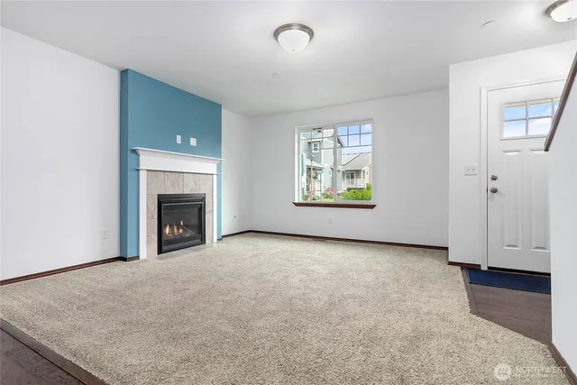 an empty room with windows and fireplace