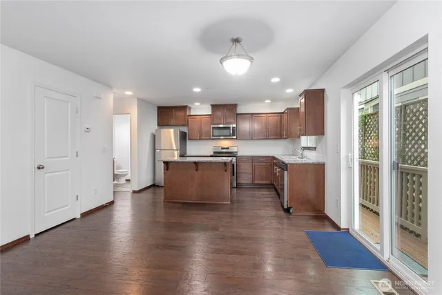 a large kitchen with stainless steel appliances kitchen island a large counter top and a wooden floors