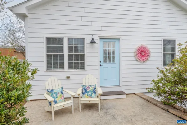 a front view of a house with a chairs and table in a patio