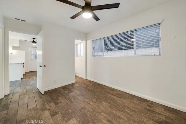a view of empty room with wooden floor and windows