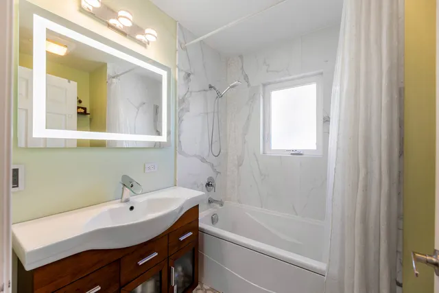 a bathroom with a tub sink and mirror