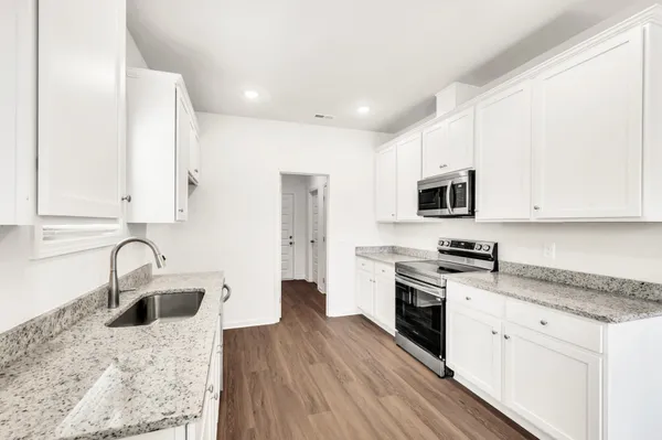 a kitchen with a sink stove top oven and microwave